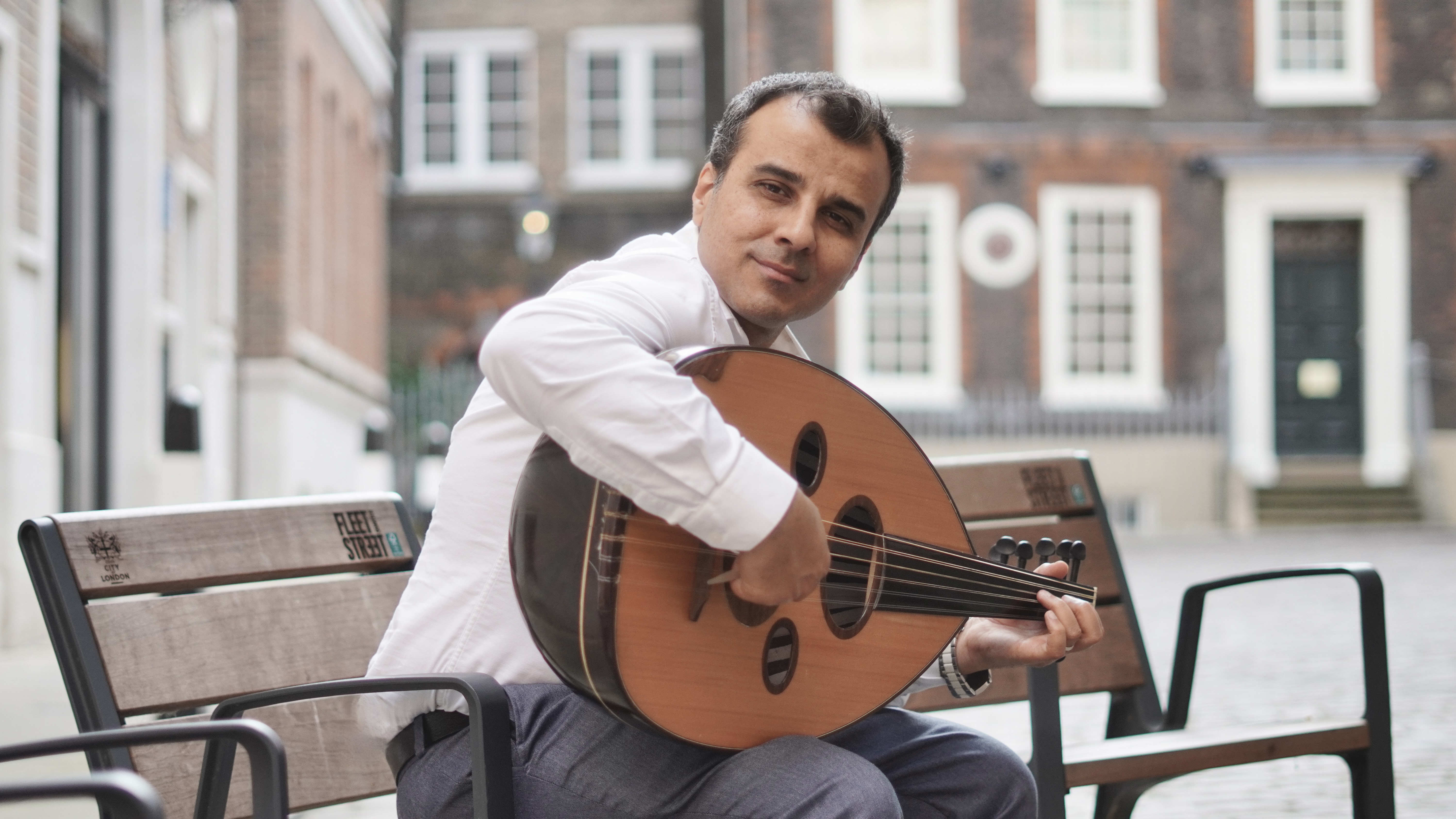 Saife Al-Naffakh playing oud at a concert.